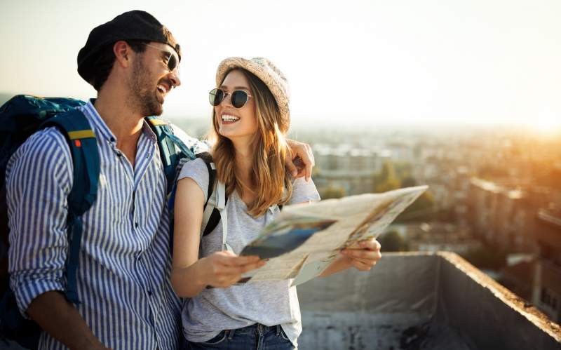 happy tourists sightseeing with map