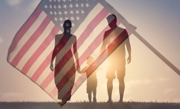 double exposure of family holding hands and american flag