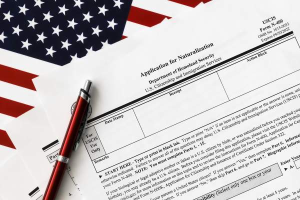 Application for naturalization, a pen, and an American flag