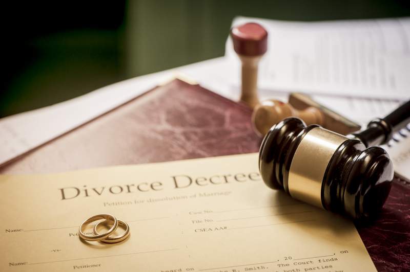 discarded wedding bands sit on a decree of divorce