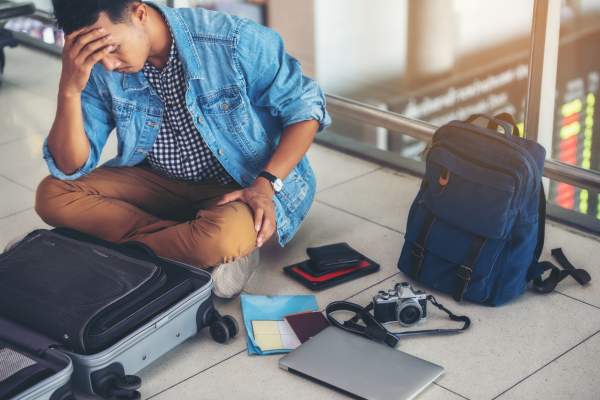 distraught traveler with items strewn about is missing documents
