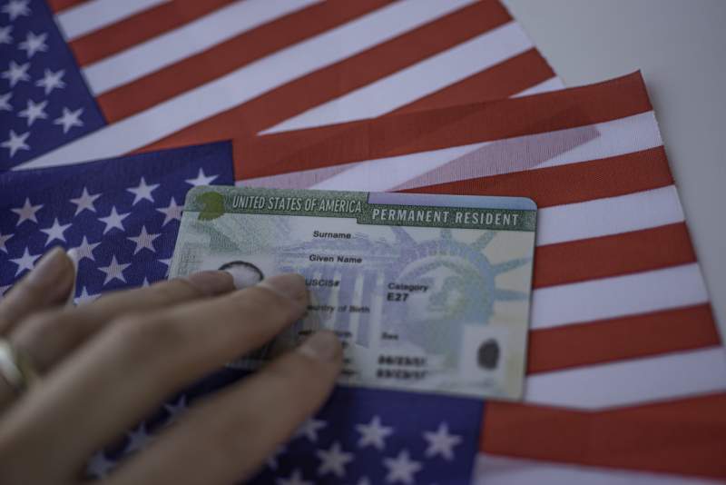 green card resting on american flags