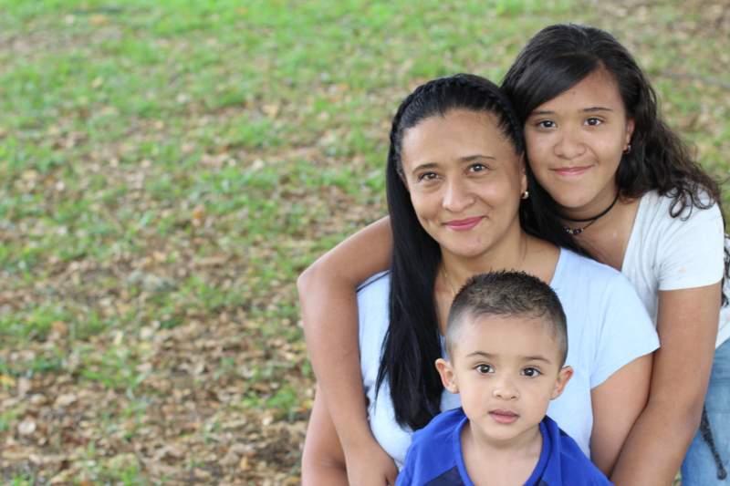 Happy mother with her daughter and son in a park setting.