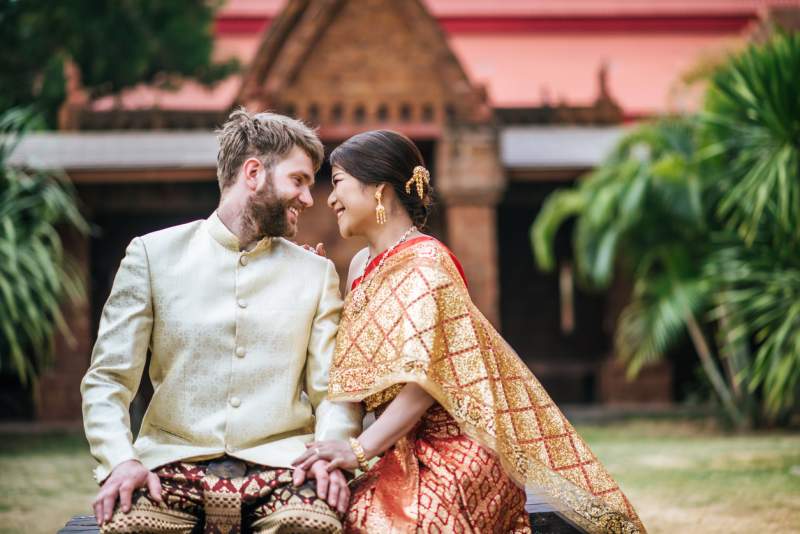 intercultural bride and groom in thai wedding attire