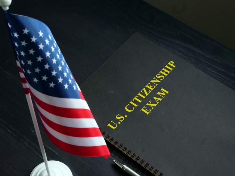 united states citizenship exam book and american flag