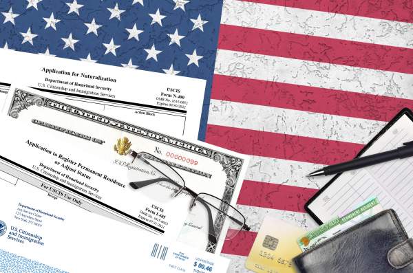 uscis form i-485 with supporting documents on american flag